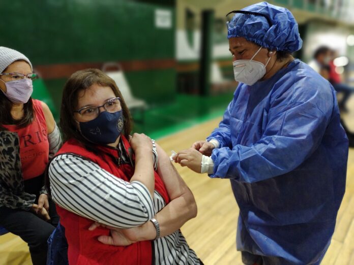 El Ministerio de Salud ha recomendado reforzar la vacunación contra el coronavirus, enfocándose especialmente en las personas mayores de 50 años y aquellas con condiciones de riesgo, debido al aumento de casos en las últimas semanas. Se destaca la importancia de mantener actualizada la aplicación de dosis de refuerzo para prevenir complicaciones, hospitalizaciones y muertes por la enfermedad. El comunicado también informa que en la segunda semana de enero se registraron 2,583 casos confirmados y 3 fallecimientos por Covid-19. Se subraya la estrategia de refuerzo de vacunas, especialmente para personas de alto riesgo, como mayores de 50 años, personas gestantes y aquellos con inmunocompromiso. Se recomienda una dosis de refuerzo si han pasado más de seis meses desde la última aplicación, independientemente de la cantidad de refuerzos anteriores. Las personas menores de 50 años con comorbilidades y las personas con mayor riesgo de exposición se consideran en un grupo intermedio de riesgo. Se sugiere un refuerzo anual si ya recibieron uno en los últimos 6 meses. Aquellas con bajo riesgo de complicaciones deben recibir una vacunación de refuerzo anual. Se destaca que todas las jurisdicciones cuentan con suficientes dosis para completar esquemas de vacunación y aplicar refuerzos, y se alienta a las personas a asistir a los vacunatorios de forma espontánea. Las coberturas totales del esquema primario completo son del 82.4%, con un 91% en personas mayores de 18 años. La población que recibió el primer refuerzo es del 49.6%, llegando al 75% en mayores de 50 años. En cuanto al segundo refuerzo, la población mayor de 50 años presenta una cobertura mayor al 40%, y cerca del 45% en mayores de 60 años.