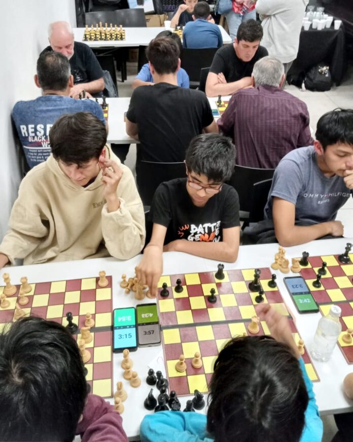 En las últimas semanas, se puso en marcha y avanzó de buena manera un nuevo espacio de encuentro y competencia organizado por la Comuna a través de la dirección general de Deportes. Se trata de la Liga Municipal de Ajedrez, el primer certamen municipal de la disciplina, que es animado por varias decenas de jugadores que desarrollan la actividad en las diferentes sedes que la Escuela Municipal de Ajedrez tiene en los Clubes Municipales. “Estamos muy contentos y a la vez orgullosos por pener en marcha este espacio con el que buscamos, entre otras cosas, que los chicos y las chicas de la Escuela Municipal de Ajedrez puedan tener su primer espacio de competencia formal”, destacó el director general de Deportes, Fernando Trillo. Además, Trillo dejó en claro que “la Liga es para jugadores de todas las edades y de todos los niveles de juego, siempre que sean alumnos de la Escuela Municipal”. “Por lo que vinos en estas dos fechas iniciales, la idea prendió fuerte y la gente está entusiasmada. Vino gente de todas las sedes de la Escuela y los que no participaron de las primeras fechas se pueden sumar en la próxima", agregó. La 1° fecha se llevó a cabo en el Microestadio “Ricardo Rusticucci, mientras que la 2° se desarrolló en las instalaciones de la Casa de la Cultura, ubicada en el centro de Pilar. En principio, el certamen constará de dos fechas más. Se disputará un torneo en cada una de las cuatro fechas, por lo que en cada jornada se entregarán puntos y al final del calendario, el que más puntos sume se consagrará campeón de la Liga Municipal. “La idea surgió del Inter Polis que se hizo hace poco en el “Rusticucci”. La propuesta estuvo buena y queriamos que no quede como algo que ocurre una vez al año sino extenderlo a lo largo de la temporada y darle continuidad a través de una serie de fechas”, confió el maestro Boris Papez, quien comparte el trabajo docente en la Escuela Municipal de Ajedrez junto a su colega Raúl Pérez. El profesor explicó que “cada fecha de Liga se juegan cinco rondas (eventualmente puede ser alguna más) y de acuerdo a los resultados registrados, cada fecha entrega un ganador y la cantidad de puntos correspondiente”. “El tiempo de juego es de 5 minutos por jugador mas 5 segundos de adición”, agregó. Hasta el momento, el puntero es Kevin Villaverde (Club Municipal Del Viso) con 8,5 puntos, escoltado por Samuel Llerena (Del Viso) con 8 y tercero aparece Brian Guillen (Club Municipal Tribarrial) con 7 unidades. Con 6 puntos se ubican Dylan Alfaro Díaz (Tribarrial), Facundo Caballero (CCF/Rusticucci), Hugo Valdez (Tribarrial), Víctor Della Vedova (Club Municipal Peruzzotti), Natanael Zapata (Del Viso), Santino Pérez (Tribarrial), Gael Centeno (Tribarrial) y Fernando Santillán (CCF/Rusticucci). Vicente Escot (CCF/Rusticucci) tiene 5 unidades y César Vega (Peruzzotti) acumula 4,5. Con 4 puntos empatan Santino La Comba (Tribarrial), Ludmila Vega (Peruzzotti), Emiliano Fernández (Tribarrial) y Victoria Altamirano (Club Municipal Lagomarsino). Más abajo, con 3,5 unidades, están E. Martínez (Del Viso), Jesús Tancara (Tribarrial), Lionel Tripelhorn (Lagomarsino) y Franco Palacios (CCF/Rusticucci). La lista sigue con Fernando Thames (Del Viso), A. Pérez (Del Viso), Sofía Gómez (CCF/Rusticucci), Santino Correa (Del Viso), Paz Melgarejo (CCF/Rusticucci) y Bastian Villaverde (Del Viso), que suman 3 puntos. Aaron Parrado (Del Viso) acumula 2,5 unidades, en tanto Hilario Bango (CCF/Rusticucci) Ailén Carmona (CCF/Rusticucci), Umma Sánchez (Tribarrial), Karen Molina (CCF/Rusticucci), Santino Mendoza (CCF/Rusticucci), Ayelén Obregón (Tribarrial), Vladimir Torres (Club Municipal Luchetti), Ioyi Kishosawa (CCF/Rusticucci), S. Geres (Del Viso), Santiago Rivarola (CCF/Rusticucci), Rosmari Rojas (Tribarrial), Alexis Guillén (Tribarrial), Javier Crespo (Lagomarsino), Galo Melgarejo (CCF/Rusticucci) se quedaron con 2. Joaquín Neira (Lagomarsino) reúne 1,5 puntos, mientras que con 1 se posicionan J. Ávila (CCF/Rusticucci), Julia Del Bueno (Tribarrial), A. Paredes (CCF/Rusticucci), S. Ruiz (Tribarrial), Julián Robasio (CCF/Rusticucci), P. Parejo (CCF/Rusticucci), Bruno Del Bueno (Tribarrial), Donato Martínez (Del Viso), Máximo Jacquet (Tribarrial), Cristian Duarte (Lagomarsino), Juan Lencina (Lagomarsino), Bruno Saura (Lagomarsino), Ian Valenzuela (Lagomarsino). Finalmente, con 0,5 unidades están Chiara Bardina (CCF/Rusticucci) y Araceli Molina (CCF/Rusticucci) 0,5, cerrando Morena Contreras (CCF/Rusticucci) y Dante Povorosnik (CCF/Rusticucci) sin puntos hasta el momento. La table de posiciones por club muestra arriba al Club Municipal Tribarrial con 53,5 puntos y luego se encolumnan CCF/Rusticucci con 45,5, Del Viso con 43,5, Lagomarsino con 15, Peruzzotti tiene 14,5 y Luchetti Cierra con 2 unidades. ***CUADRO*** Escuela Municipal de Ajedrez La Escuela Municipal de Ajedrez es gratuita, para vecinos a partir de los 7 años, la conducen los maestros Raúl Pérez y Boris Papez y funciona en cinco sedes. En el Centro Cultural Federal de Pilar las clases se dictan los jueves de 17 a 19, en el Club Municipal Luchetti los viernes de 16 a 17.30, mientras que en el Club Municipal Tribarrial se practica los sábados de 9 a 11. Además, en el Club Municipal Del Viso, los entrenamientos se desarrollan los sábados de 15 a 17 y en el Club Municipal Peruzotti los sábados de 9 a 10.30.